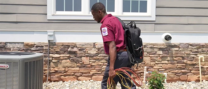 Technician walking outside preparing to completing AC service
