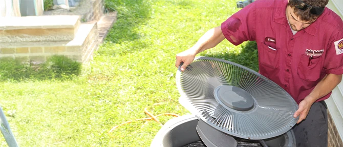 Technician servicing an outdoor AC condenser unit