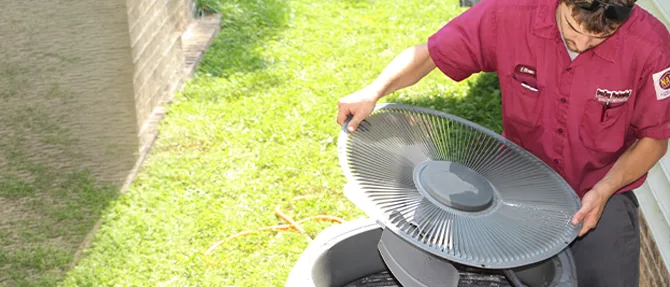 Technician inspecting an outdoor central air conditioning unit.