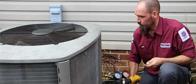Technician diagnosing a heat pump outdoor unit
