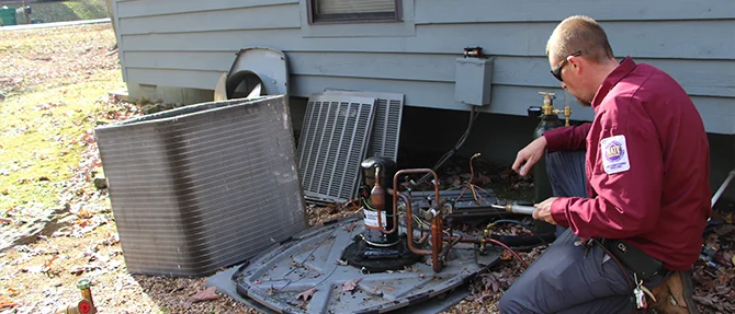 Technician repairing an outdoor HVAC unit.