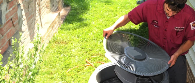Technician removing the cover from an outdoor HVAC unit.