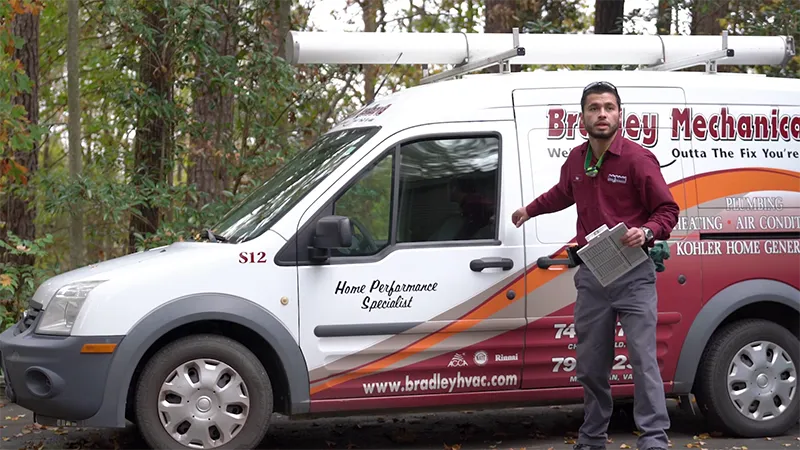 BM tech standing beside service van while holding air filter.