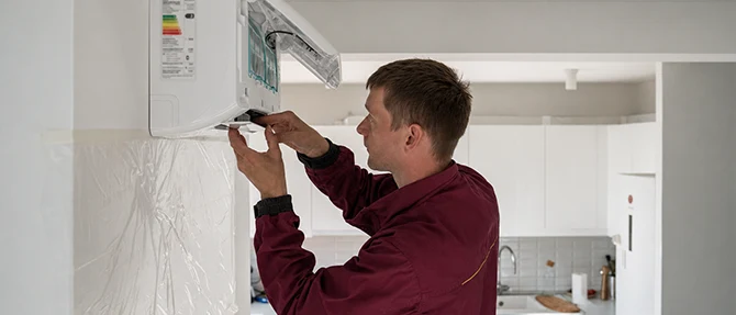 Technician servicing a wall-mounted mini-split system.