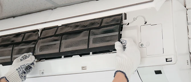 Removing dirty filters from a wall-mounted mini-split system.