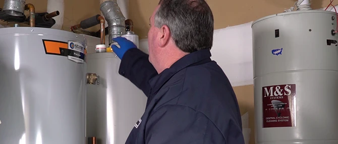 Technician inspecting tank storage water heaters.